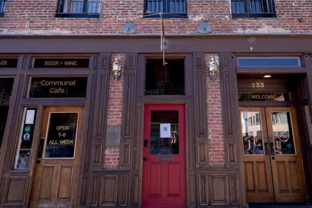 a brick building with a red door on a street at Speakeasy Suites Sleeps 18 in Nevada City