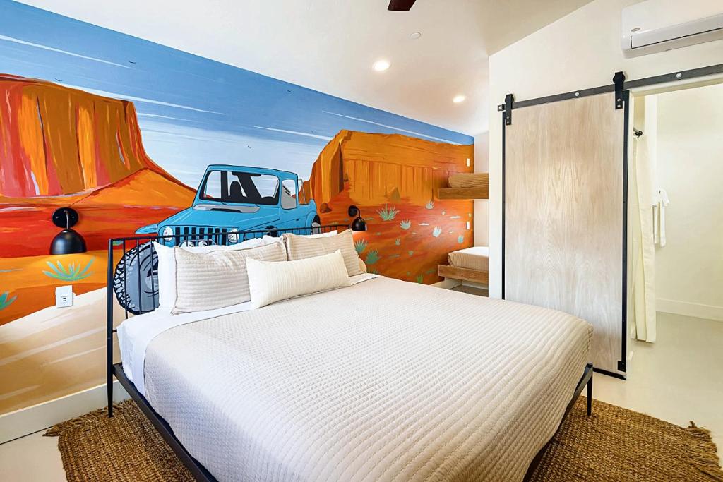 a bedroom with a bed with a painting of a truck at Downtown Kokopelli West 9 - Newly Remodeled Stylish Studio in Moab