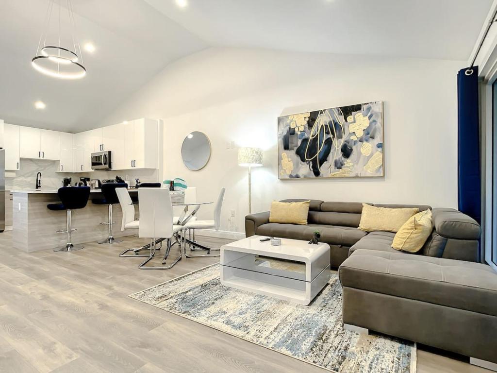 a living room with a couch and a table at Luxe Home - Heated Pool I 5 min to Beach I BBQ Grill in Fort Lauderdale