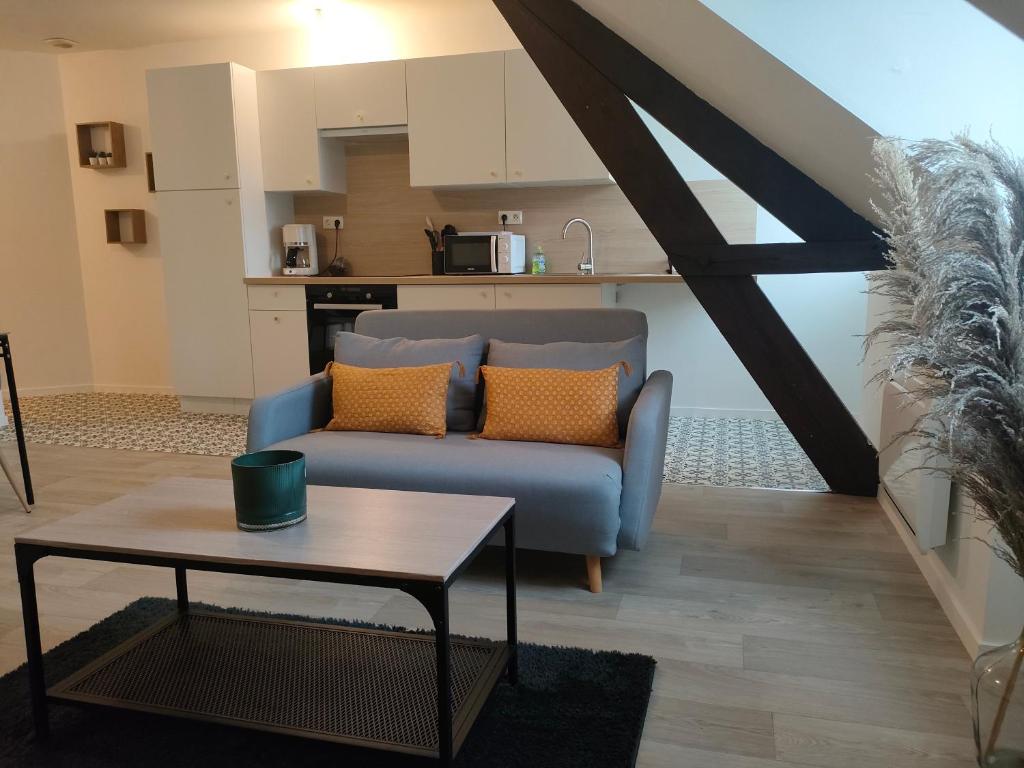un soggiorno con divano blu e tavolo di L'escapade a Fougères