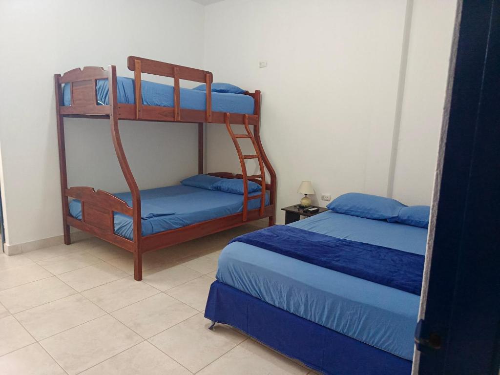 a bedroom with two bunk beds with blue sheets at Sol de Ayangue in Ayangue