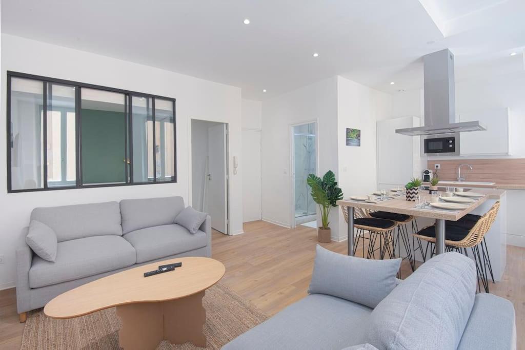 a living room with a couch and a table at Les Halles & Le port - Grand T2 haut de gamme in Toulon