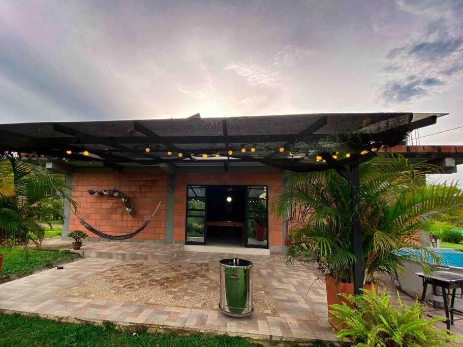 een patio met een zwarte paraplu voor een huis bij Finca San Rafael cerca al rio Wifi 6-12 personas in San Rafael