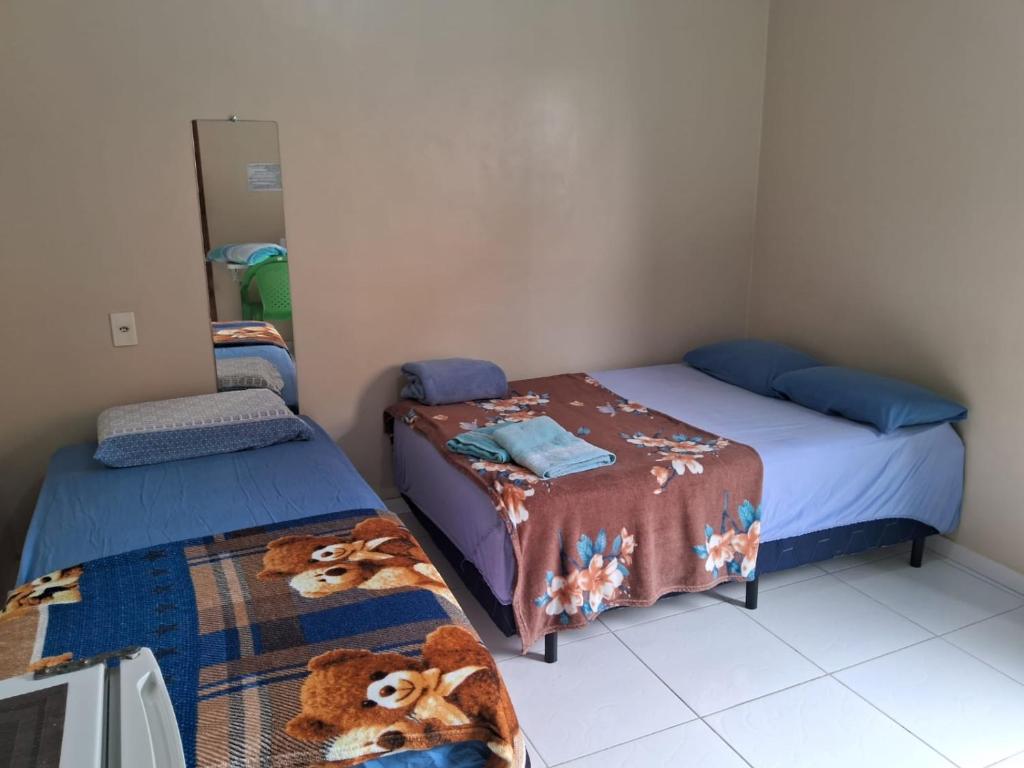 a bedroom with two beds and a mirror at Edward Suíte Manaus 03 in Manaus