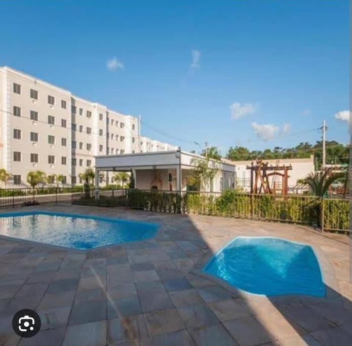 Басейн в или близо до Apartamento Aconchegante em Serra condomínio com piscina 2QTS