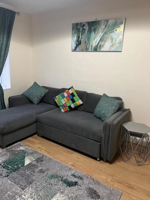a black couch in a living room with a table at Very Spacious Two Bedroom Apartment in Grays Thurrock