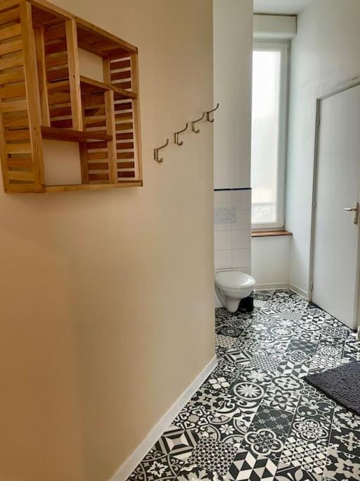 a bathroom with a toilet and a tile floor at Madini-Breizh :T3 cœur de ville in Lannion