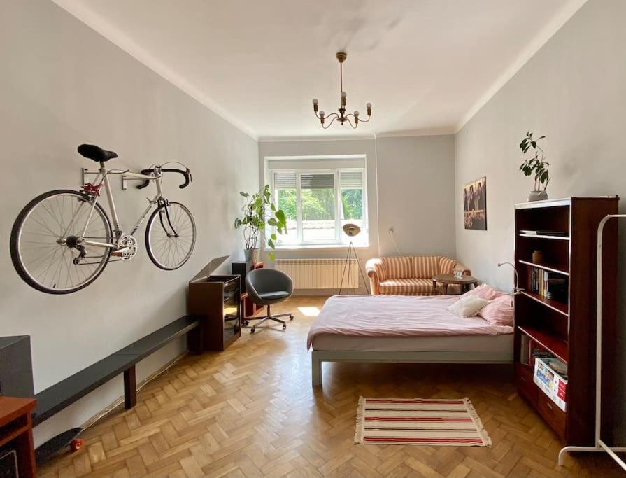 ein Schlafzimmer mit einem Bett und einem an der Wand hängenden Fahrrad in der Unterkunft Mieszkanie Centrum 60 m na wylacznosc in Lublin