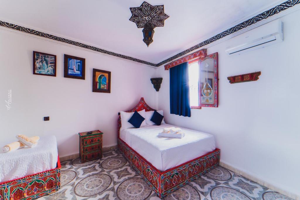 سرير أو أسرّة في غرفة في Hotel Chefchaouen