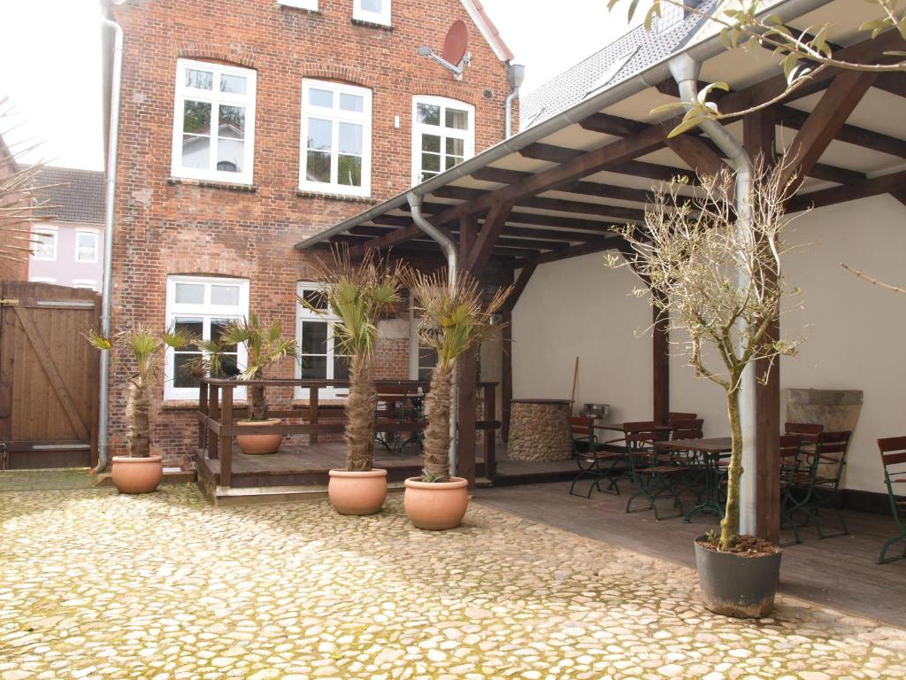 a patio with potted plants and a brick building at Lodge am Oxenweg in Husum