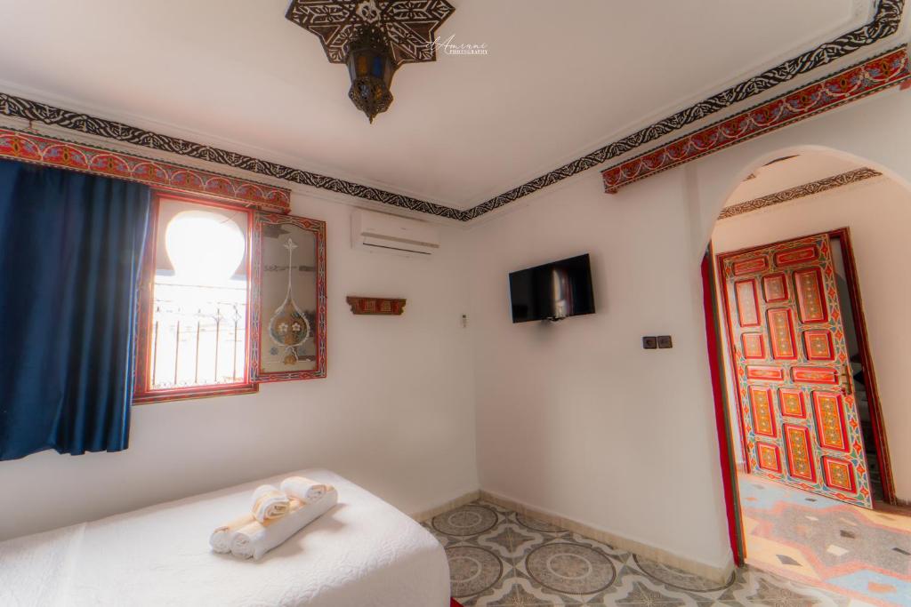 um quarto com uma cama e uma janela em Hotel Chefchaouen em Chefchaouen