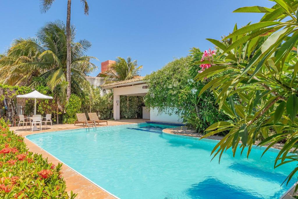 a swimming pool in front of a villa at Pousada Katavento #Q2 - Suíte Dupla por Carpediem in Cumbuco