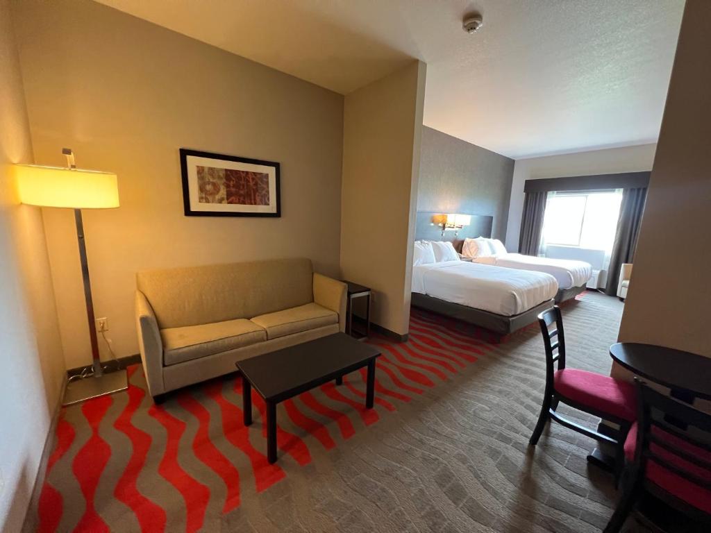 een hotelkamer met een bank en een bed bij Comfort Suites Boise West Meridian in Meridian