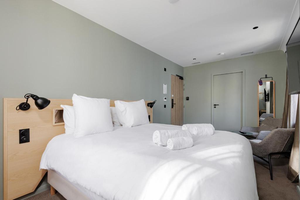 a bedroom with a large white bed with white pillows at Des Sept - Entrée autonome, réception en ligne - Encore Mieux in Orléans