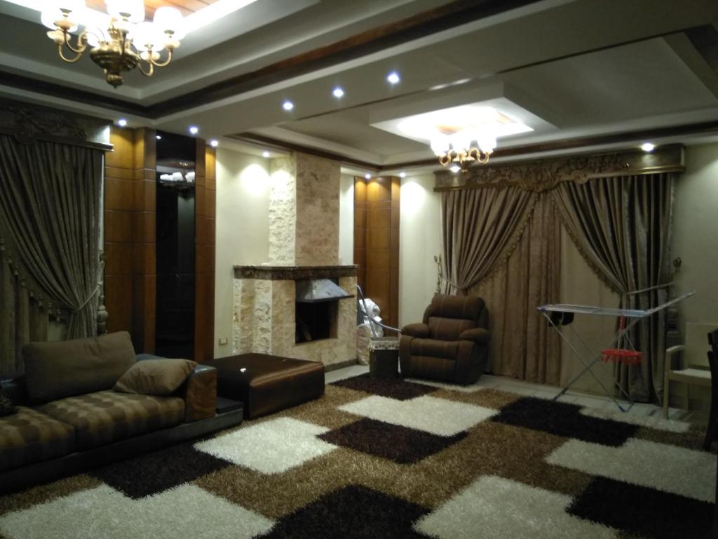 een woonkamer met een bank en een open haard bij 5th Settlement Shaya in Caïro