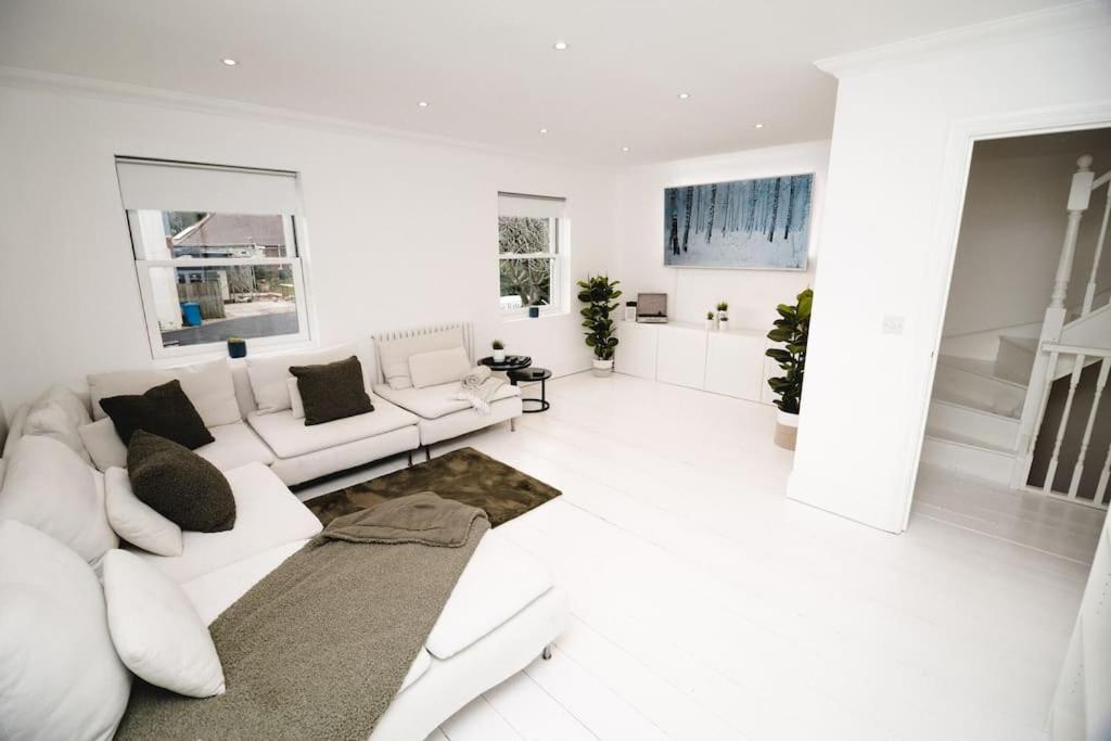 - un salon blanc avec un canapé et un tapis dans l'établissement Brand New Stylish Three Story House!, à Thorpe Saint Andrew
