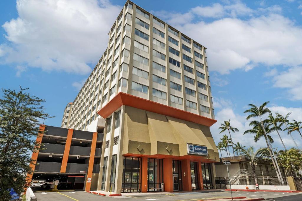 un alto palazzo di uffici con un edificio di Best Western The Plaza Hotel - Free Breakfast a Honolulu