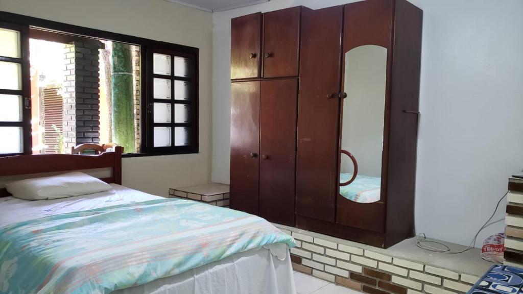 een slaapkamer met een bed, een dressoir en een spiegel bij Recanto do Sossego in Caraguatatuba