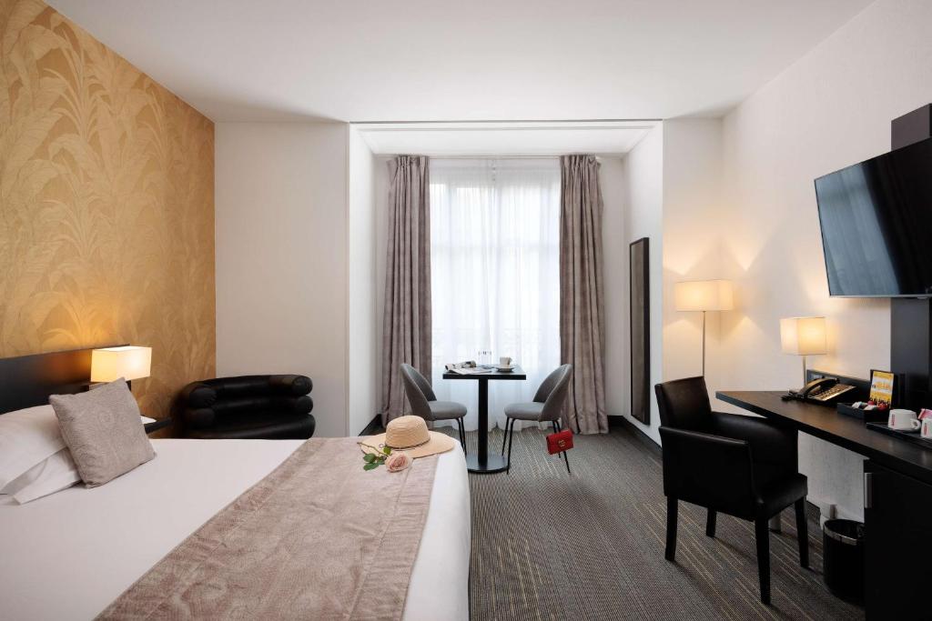 a hotel room with a bed and a table and chairs at Best Western Plus Hôtel Massena Nice in Nice