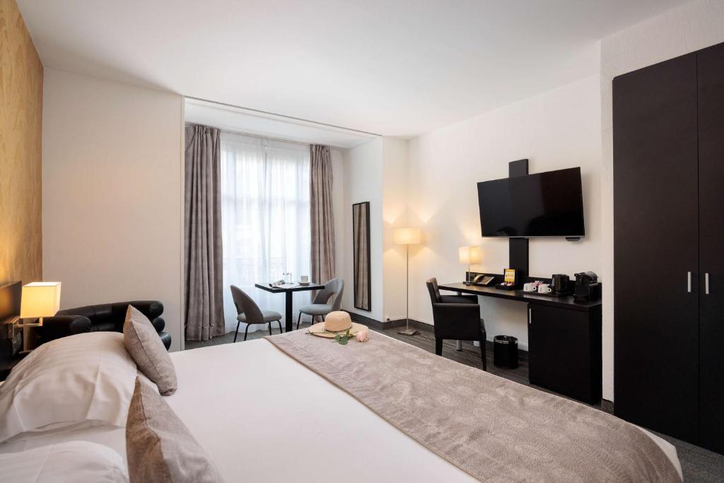 a hotel room with a bed and a desk at Best Western Plus Hôtel Massena Nice in Nice