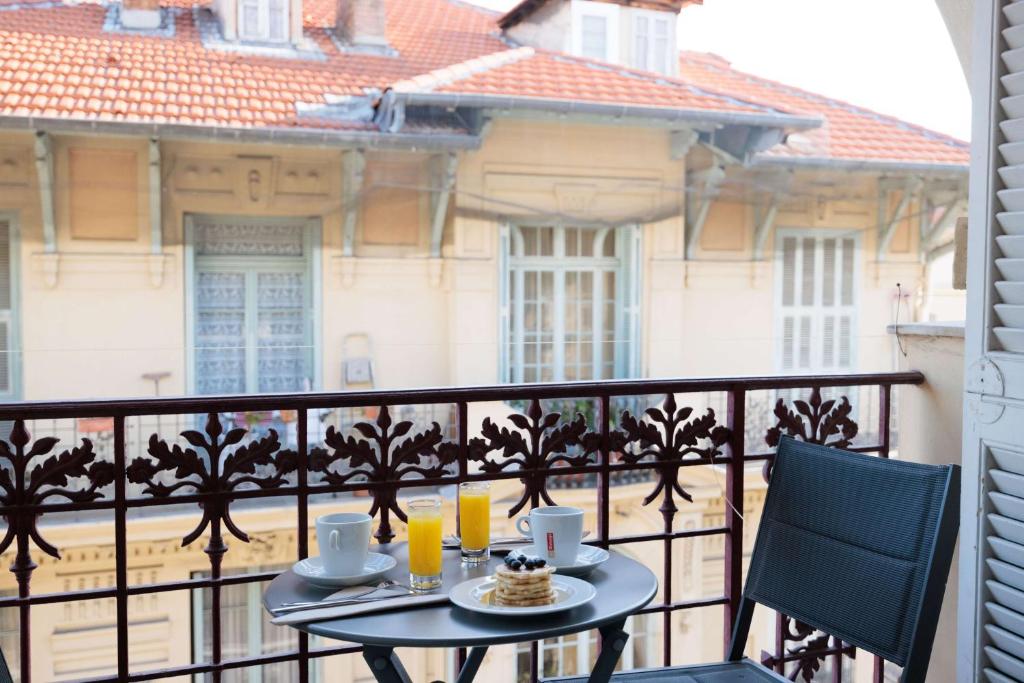 a table on a balcony with a view of a building at Best Western Plus Hôtel Massena Nice in Nice
