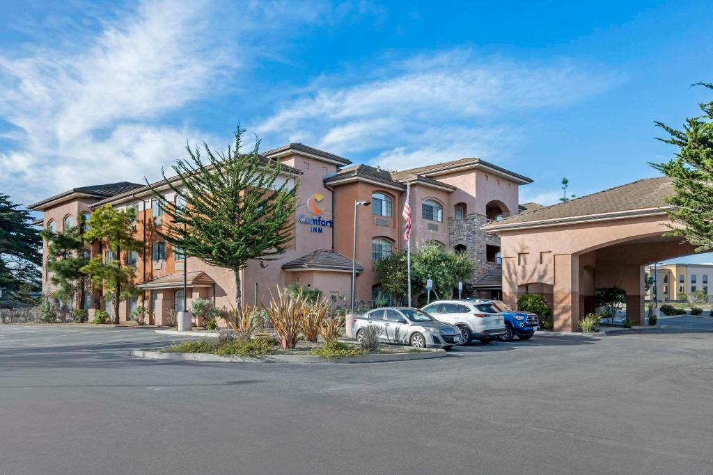 a hotel with cars parked in a parking lot at Comfort Inn Marina on the Monterey Bay in Marina