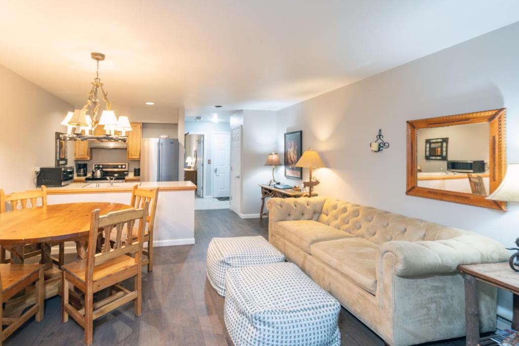 a living room and kitchen with a couch and a table at Cozy Condo steps to Coonskin lift in Telluride