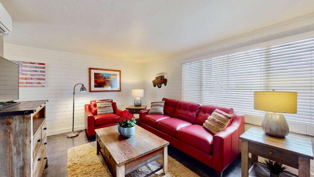 een woonkamer met een rode bank en een tafel bij Downtown Cozy Home Base - Purple Sage 2 in Moab