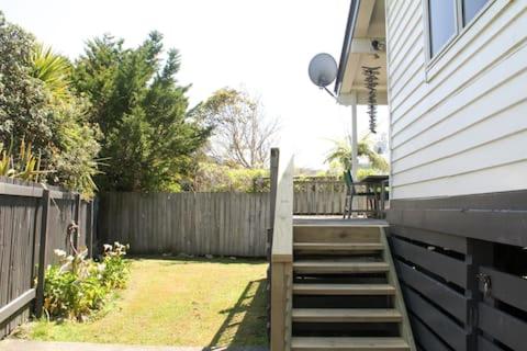 ein Haus mit einer Treppe neben einem Zaun in der Unterkunft Quiet, Private and Central in Tairua