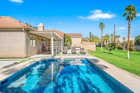 uma piscina em frente a uma casa em Luxurious Getaway Near Coachella Stagecoach Pool Putting Green Parking Firepit Sleeps 11 em Indio