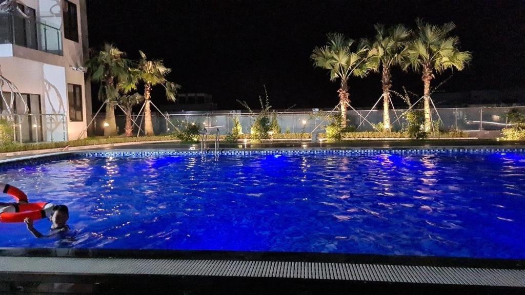 a swimming pool at night with a person in the water at Tom appartment gym and pool free, Hue in Hue