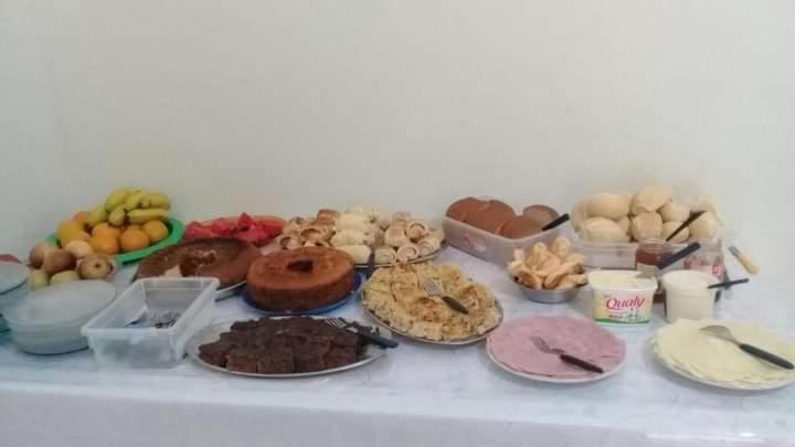 a table with many different types of food on it at Pousada Sagrada Familia in Cachoeira Paulista