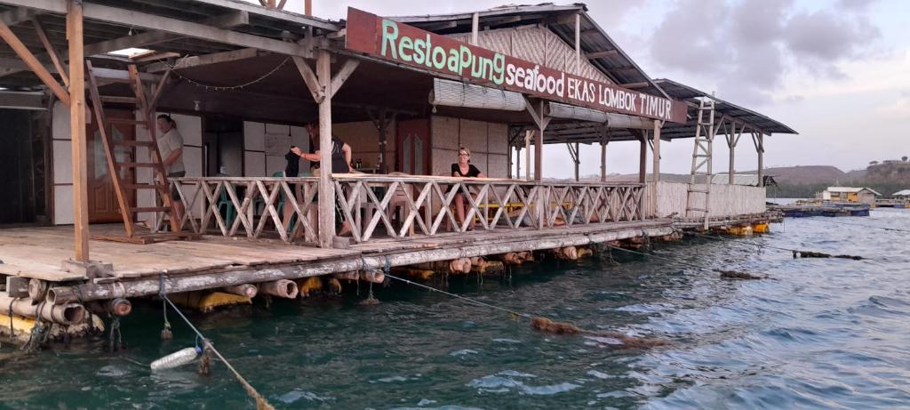 a restaurant on a pier in the water at Ekas beach floating Room and suite in Ekas