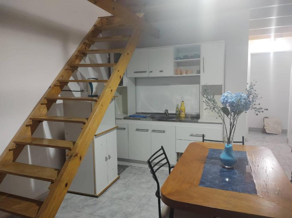 una cocina con una escalera de madera y una mesa en Departamentos Lio, en Termas de Río Hondo