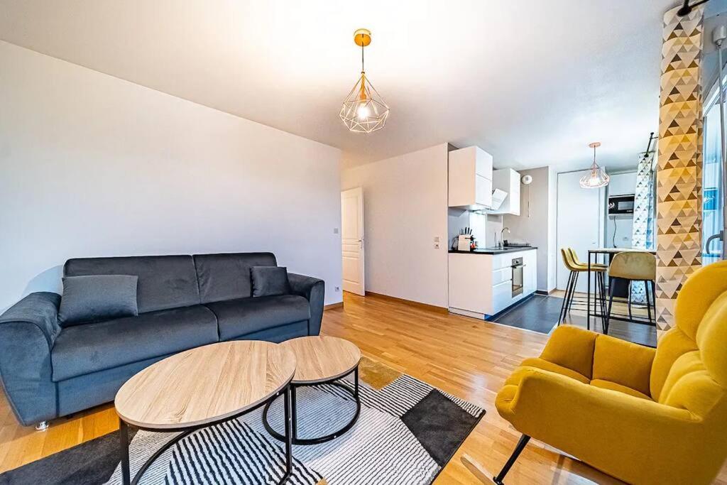 un salon avec un canapé, une table et des chaises dans l'établissement Joli T2 avec garage gratuit et balcon, à Villeurbanne