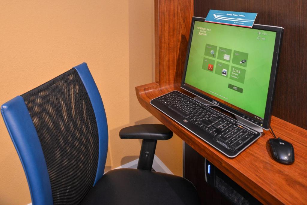 a laptop computer sitting on a desk next to a chair at Candlewood Suites St Louis St Charles, an IHG Hotel in St. Charles