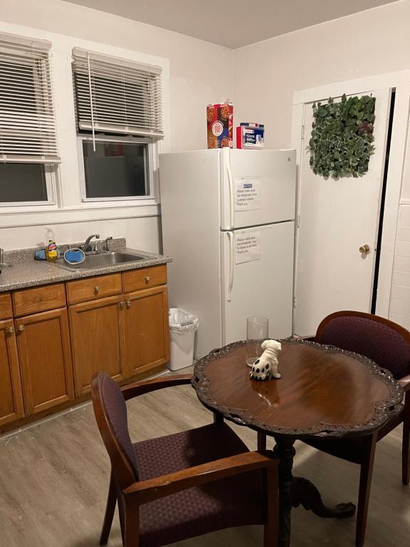 a kitchen with a table and a white refrigerator at Muna’s Place in Newark