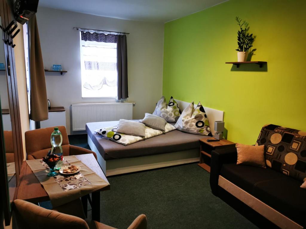 Penzion u Jezevce في هرينسكو: غرفة معيشة مع أريكة وطاولة