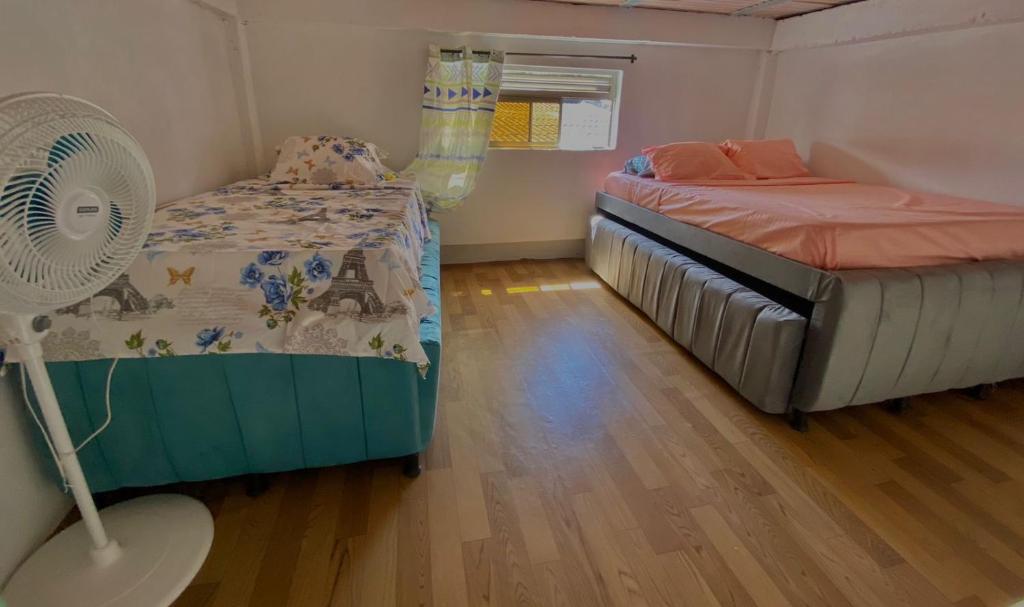 um pequeno quarto com uma cama e uma ventoinha em Aparta Hotel Manzur em Barranquilla