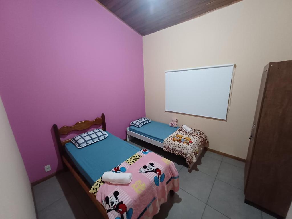 Zimmer mit 2 Betten und einem weißen Bildschirm in der Unterkunft Casa de Campo areal in Areal