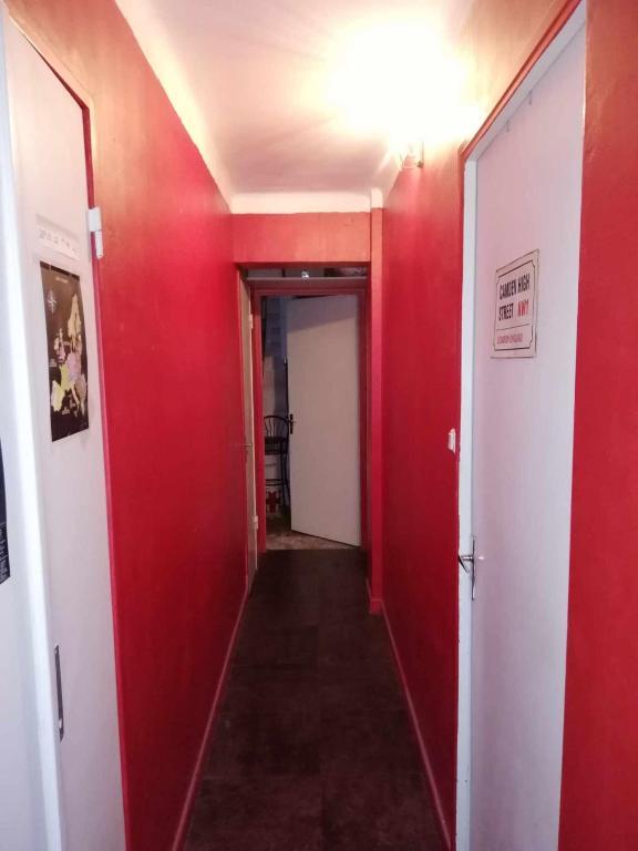 a hallway with red walls and a red door at Chambre & table d'hôte à 5 min de la gare Matabiau in Toulouse