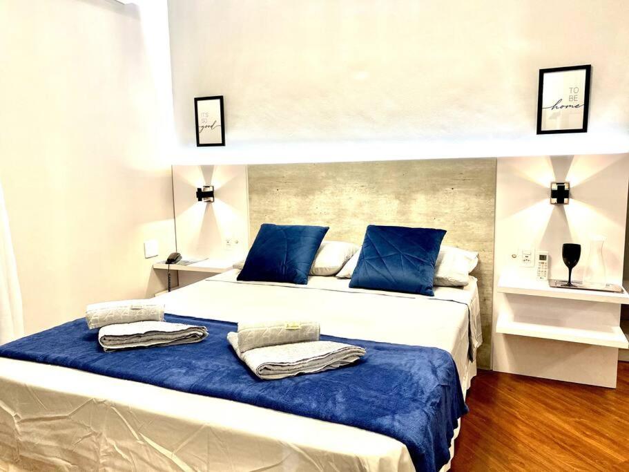 1 dormitorio con 2 camas y almohadas azules en 205 Flat/Studio Elegance Jardins- Cozinha Completa, en São Paulo