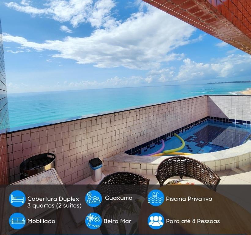 uma piscina com vista para o oceano em Cobertura Duplex Beira Mar 3 quartos em Maceió