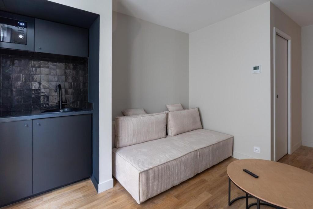 un salon avec un canapé et une table dans l'établissement Modern and elegant 1BD Apartment near Montmartre, à Paris