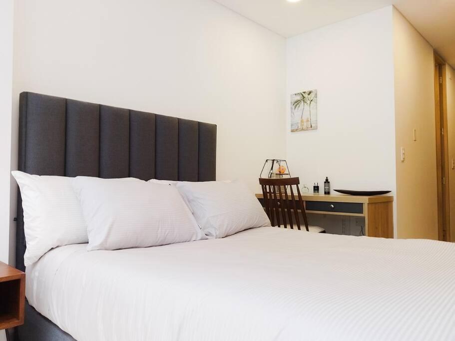 - une chambre avec un lit blanc et une tête de lit noire dans l'établissement Maravilloso loft en el centro de Chapinero 319, à Bogotá