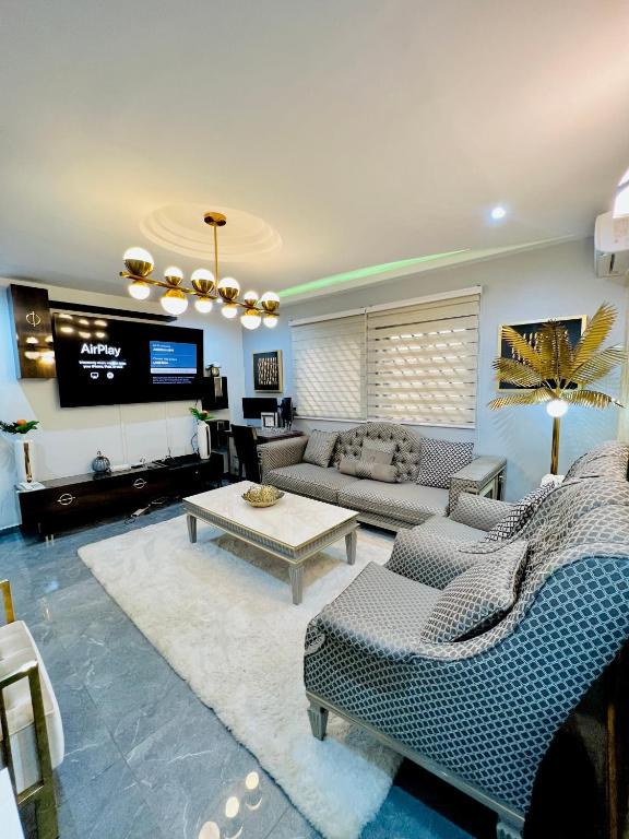 sala de estar con sofá y TV en The Jumeirah Guest Home, en Yaoundé