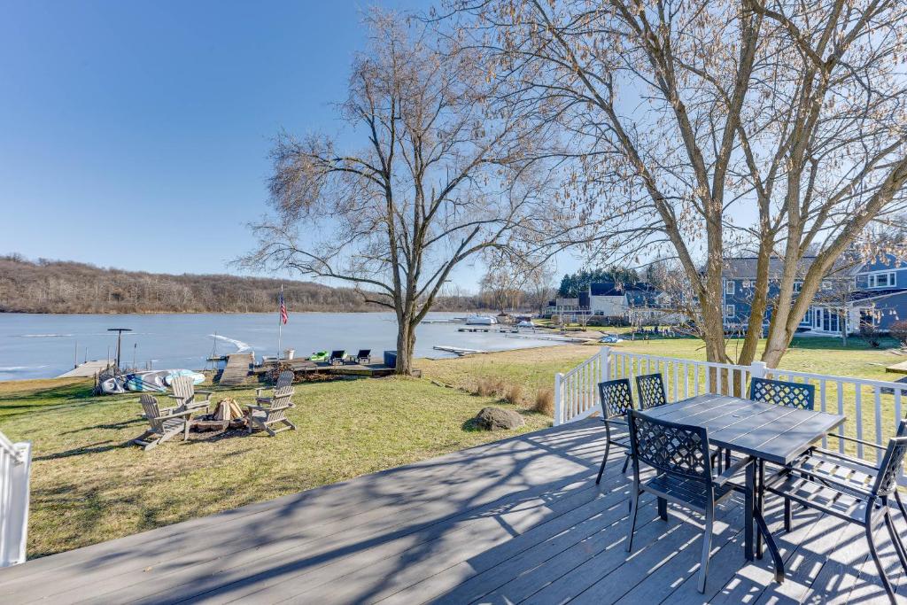 a table and chairs on a deck overlooking the water at Lakefront Highland Home with Dock about 2 Mi to Milford! 