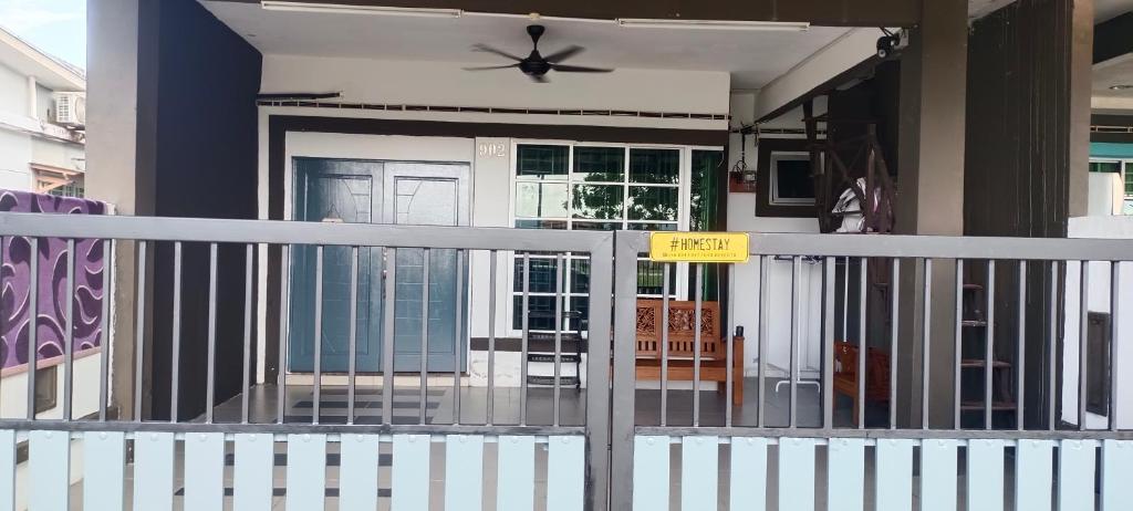 Una casa con una puerta con un cartel. en HOMESTAY D'TEPIAN CASA, BANDAR SERI IMPIAN KLUANG en Kluang