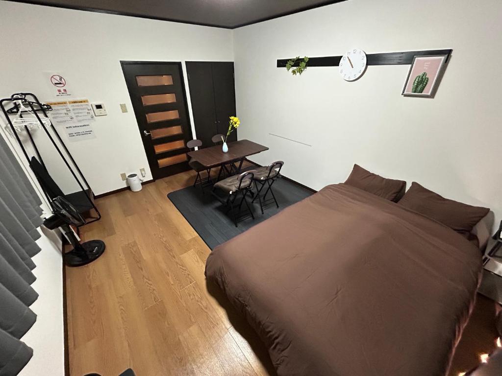 um quarto com uma cama, uma mesa e uma secretária em Guest House GENESIS OF FREEDOM INN em Fukuoka