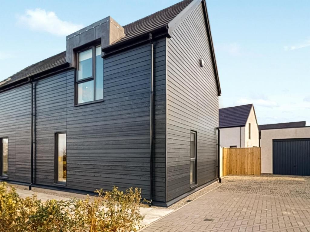 a black house with a black roof at Miller Time in Croy